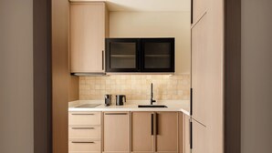 Una cocina moderna con armarios de madera clara, una campana extractora negra y un salpicadero de azulejos.