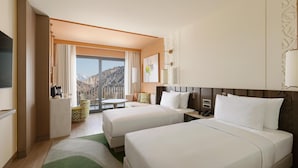 A hotel room with two beds, a dining area, a kitchen, and a large window with a mountain view. - Beldersoy Resort and Spa, Part of Destination By Hyatt (Chimgan)