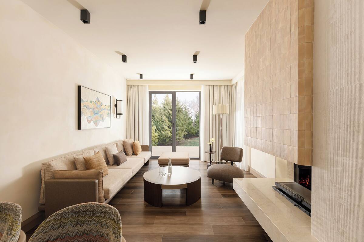 Una sala de estar moderna con sofá, mesa de centro y chimenea.