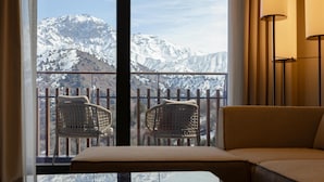 A balcony with two wicker chairs and a sofa, overlooking a snow-covered mountain. - Beldersoy Resort and Spa, Part of Destination By Hyatt (Chimgan)