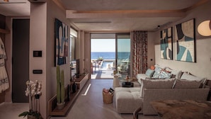 Ein modernes Wohnzimmer mit Meerblick, ausgestattet mit einer Couch, einem Couchtisch und abstrakter Kunst an den Wänden.