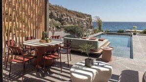 Eine Terrasse mit Pool, Sitzgelegenheiten im Freien und Blick aufs Meer.