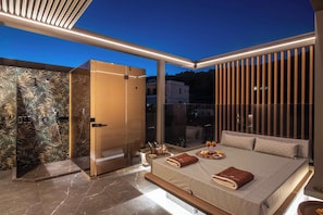 A modern bedroom with a large bed, a walk-in closet, and a glass shower enclosure. - Lapis Nera Villa II - Beachfront & Free*Heated Pool (Heraklion)