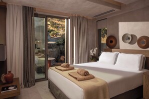 A hotel room with a large bed, a view through a glass door, and a wall-mounted light fixture. - Lapis Nera Villas - Beachfront & Free*Heated Pools (Heraklion)