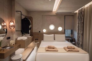 Ein modernes Hotelzimmer mit einem großen Bett, Nachttischen, einem Schminktisch mit Spiegel und einem Badezimmer.