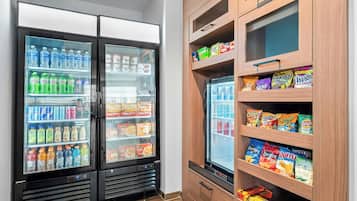 Un expositor refrigerado con diversas bebidas y aperitivos.