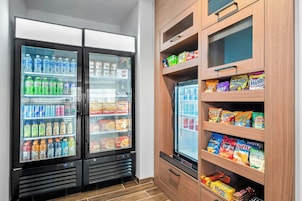 Un expositor refrigerado con diversas bebidas y aperitivos.