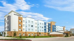 Un edificio alberghiero a più piani con tetto piatto e facciate in pietra e colori vivaci.