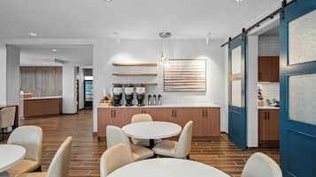 A modern kitchen with a central island, wooden cabinets, and a hanging light fixture.