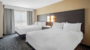 A hotel room with two beds, a large window with curtains, and a wall-mounted lamp. - Residence INN BY Marriott Waxahachie (Waxahachie)