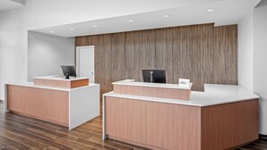 A reception area with two reception desks, a wooden panel wall, and a tiled floor. - Residence INN BY Marriott Waxahachie (Waxahachie)