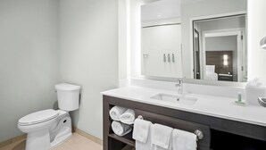 A modern bathroom with a toilet, sink, mirror, and towel rack. - Residence INN BY Marriott Waxahachie (Waxahachie)