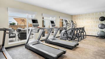 Et fitnesscenter med løbebånd, træningsbolde og en væg med motiverende tekst.