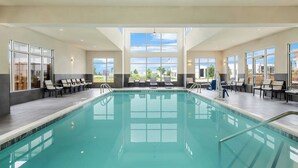 A large indoor swimming pool with clear blue water, surrounded by lounge chairs and a view of the outdoors. - Residence INN BY Marriott Waxahachie (Waxahachie)