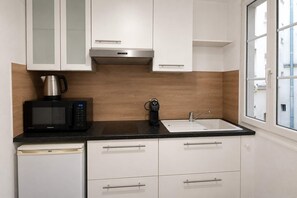 Eine moderne Küche mit Mikrowelle, Kaffeemaschine und Spüle.