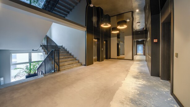 A spacious, modern hallway with a staircase leading to an upper level, featuring a mix of natural and artificial lighting. - Apartamenty Sun & Snow Rubus (Świnoujście)