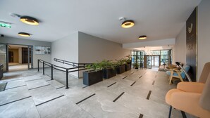 A modern lobby with a staircase, seating area, and a reception desk. - Apartamenty Sun & Snow Rubus (Świnoujście)