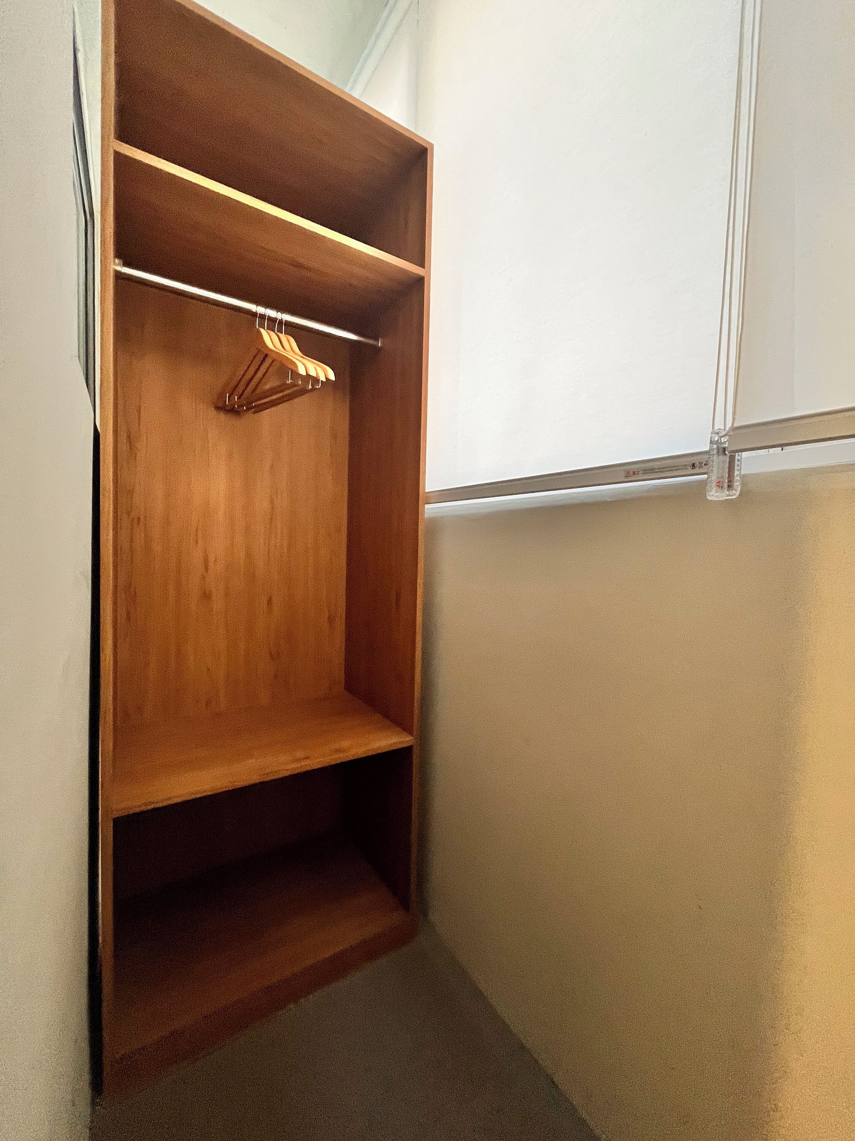 A walk-in closet with wooden shelving and a hanging rod.
