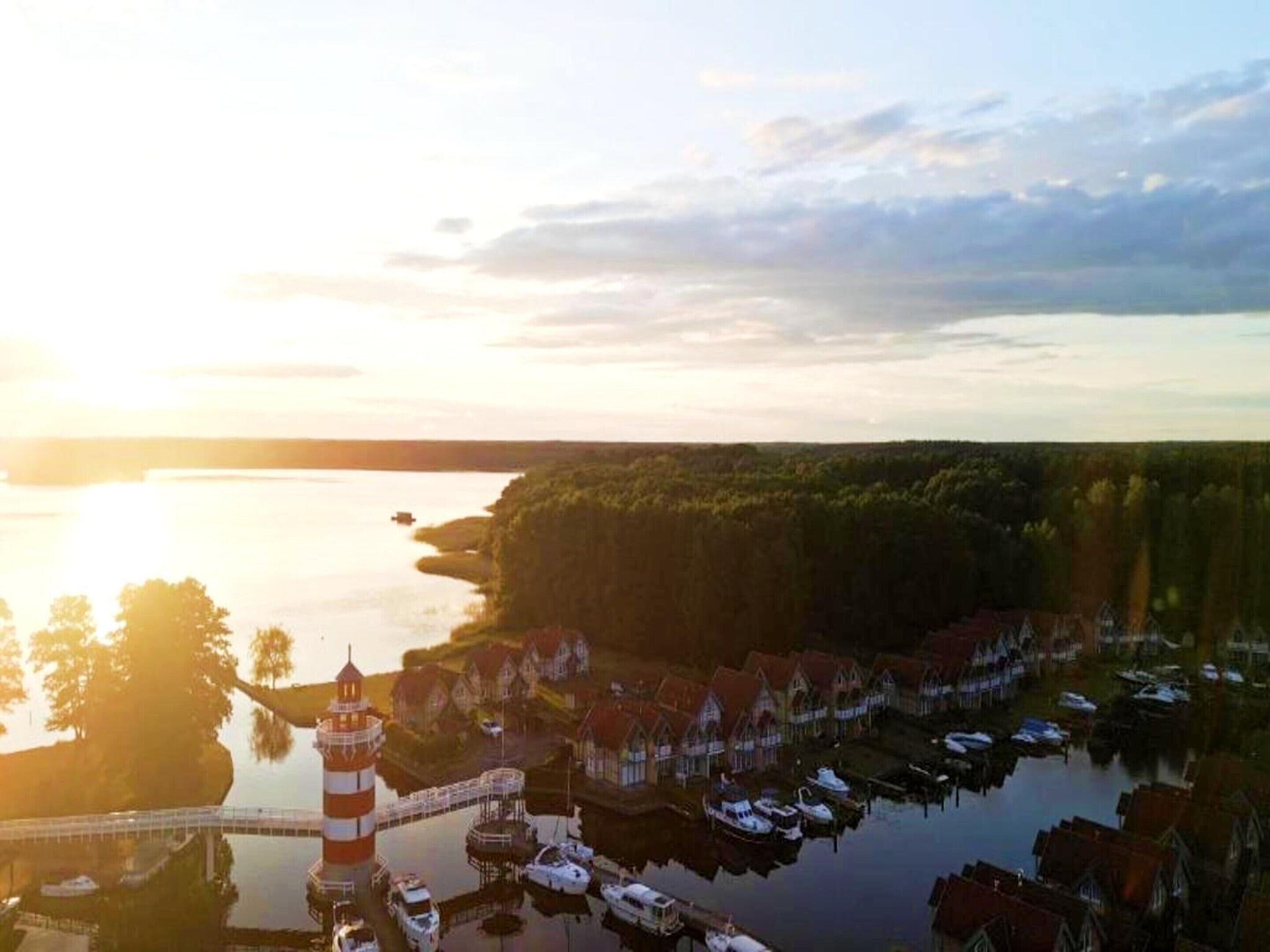 Eine Küstenstadt mit Leuchtturm, angestaute Booten und Häusern entlang des Wassers.