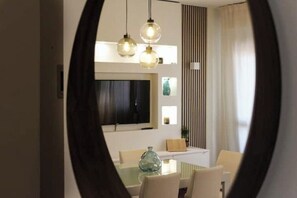 A modern dining area with a glass table, white chairs, and pendant lights. - Le Petit Nottolini - Modern comfort in the heart of Lucca, just steps from the city walls (Lucca)