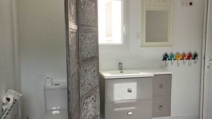 Een badkamer met toilet, wastafel en opbergkast.
