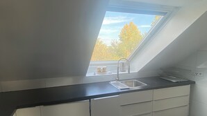 A kitchen with a skylight, a sink, and a countertop.