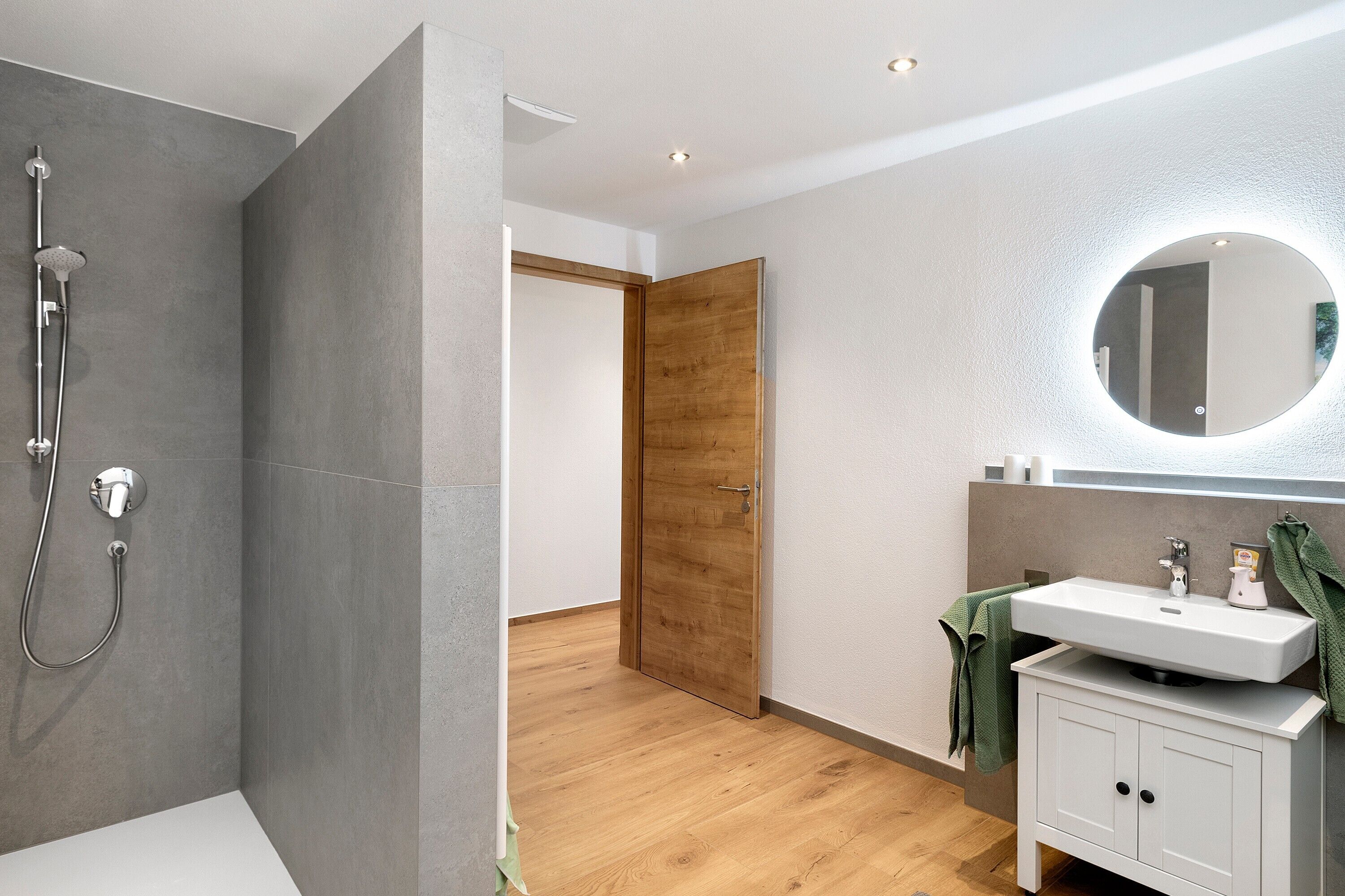 Ein modernes Badezimmer mit Dusche, Waschbecken und Spiegel.