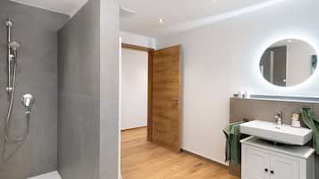 Ein modernes Badezimmer mit Dusche, Waschbecken und Spiegel.