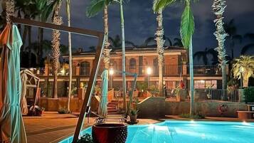 Een buitenzwembad, parasols voor strand/zwembad