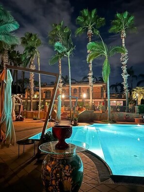 Een buitenzwembad, parasols voor strand/zwembad