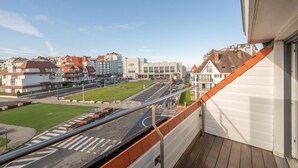 A balcony with a view of a city street, buildings, and a clear sky. - 3-Bedroom Sunny Apartment in Knokke (KNOKKE-HEIST)