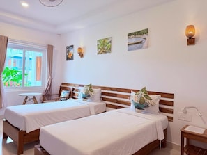 A hotel room with two beds, a small table, a window with curtains, and wall-mounted artwork. - Palma Resort Phu Quoc, Trademark Collection By Wyn (Phu Quoc)