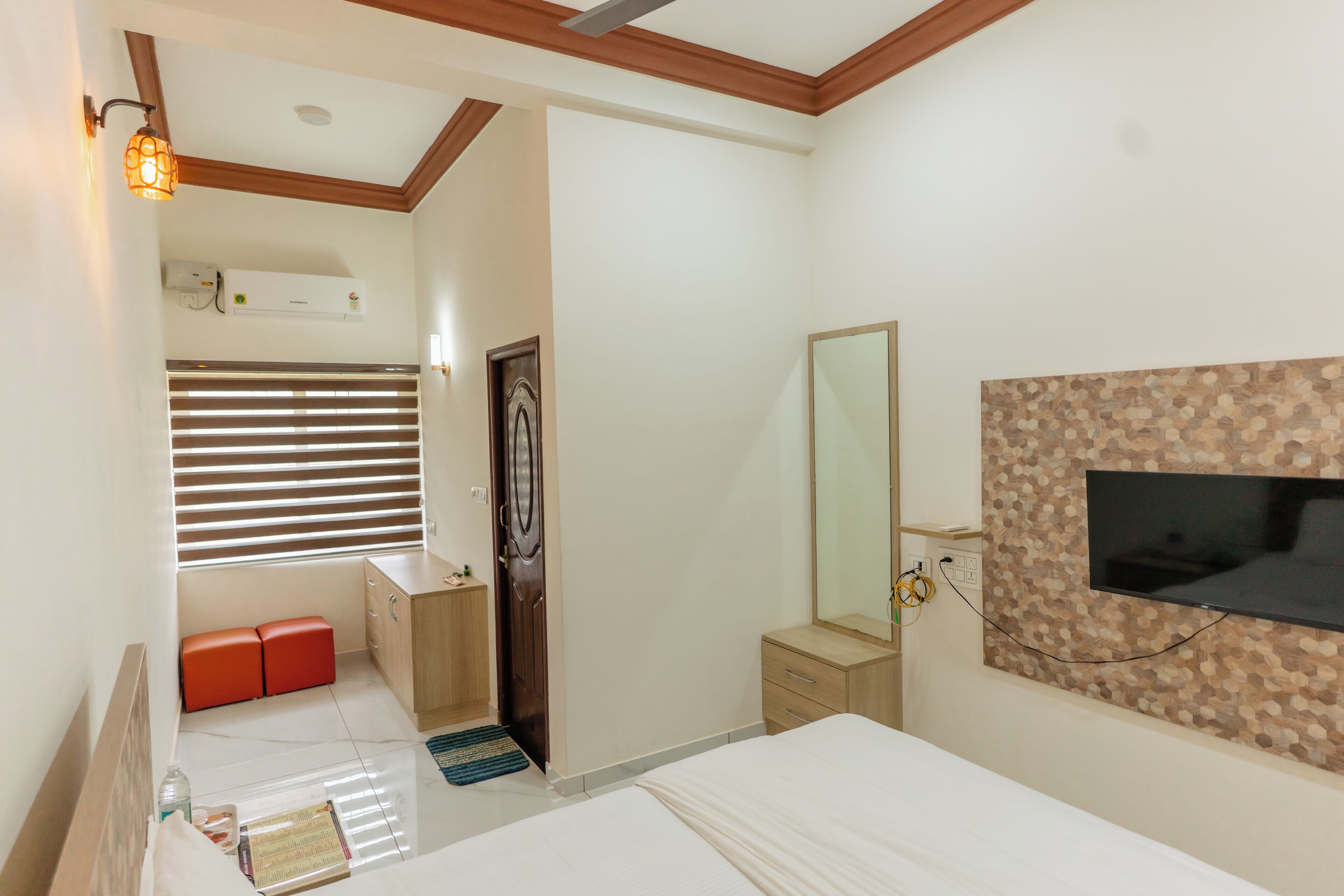 Un dormitorio con cama, cómoda, espejo, televisor y armario.