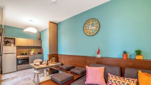 Un espacio moderno de estar con cocina, comedor y sofá con cojines.
