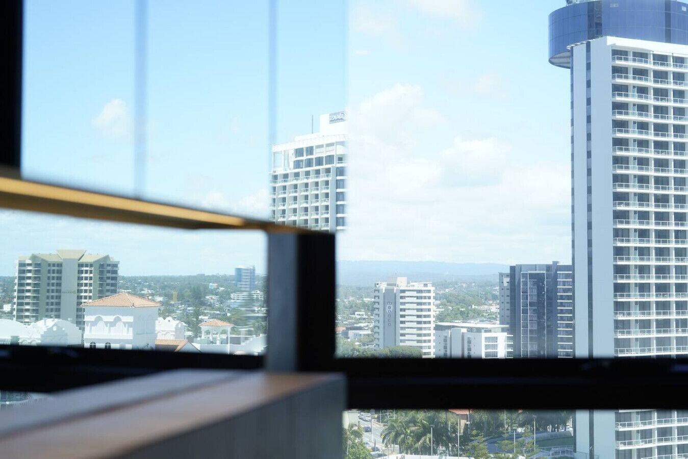 A view through a window of a cityscape with modern high-rise buildings.