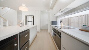 A modern kitchen with white cabinetry, stainless steel appliances, and pendant lighting. - 3 Lounges 5 Beds w/ Ducted A/C Modern & Convenient (Rochedale)