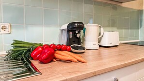 Una encimera de cocina con una cafetera Bosch, un hervidor eléctrico Bosch y verduras frescas como pimientos y zanahorias.