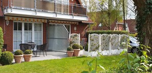 A residential property with a balcony, a patio with outdoor furniture, and a white lattice fence. - Vacation apartment Rahn Apartment 1 - Cozy two-room apartment close to the center (Timmendorfer Strand)