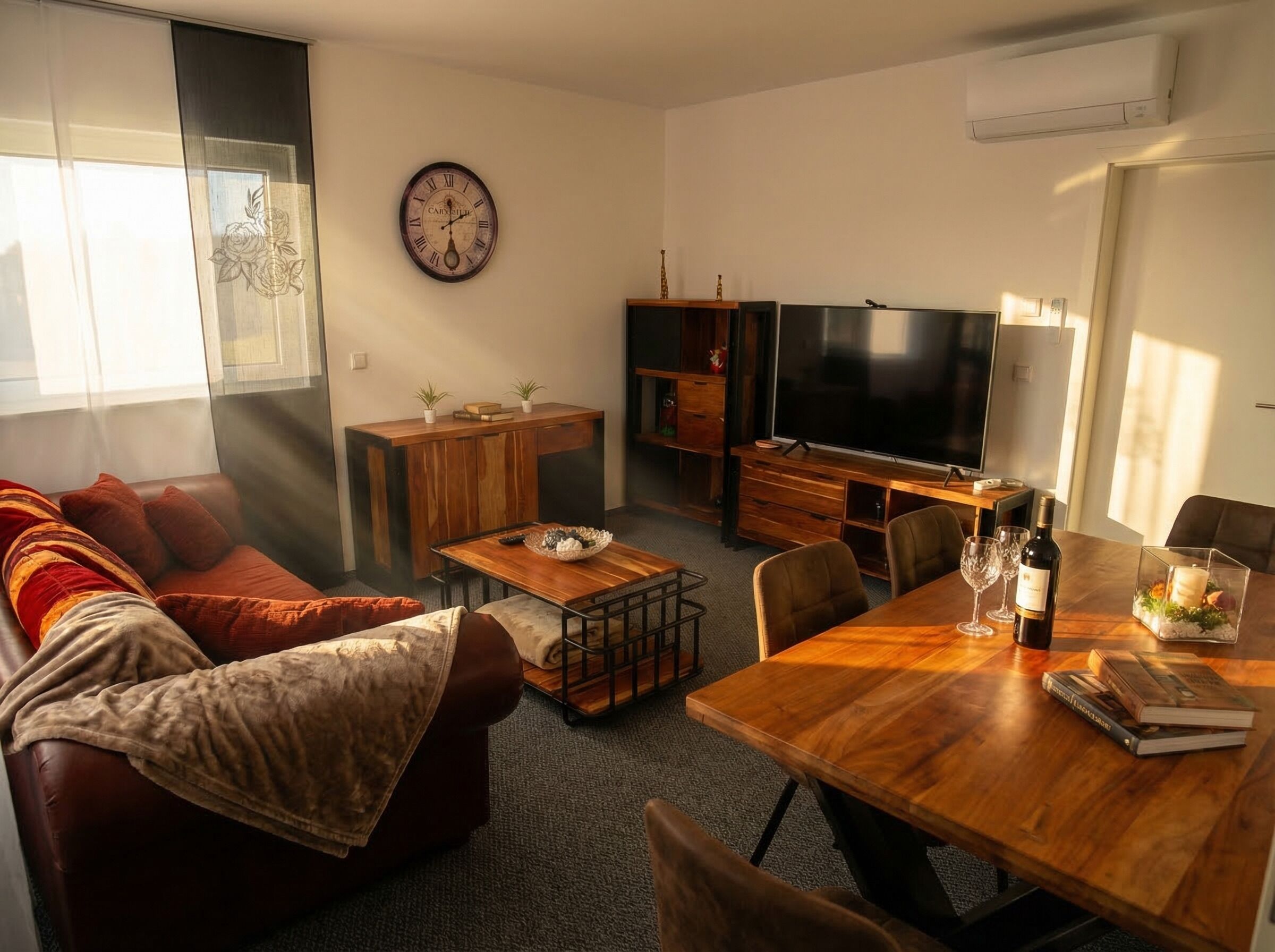 A living room with a sofa, a coffee table, a TV, and a dining table with chairs.