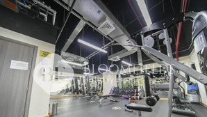 A gym with various exercise equipment, mirrors, and a black floor. - Bloomfields Deluxe 1Br Leonardo (Abu Dhabi)