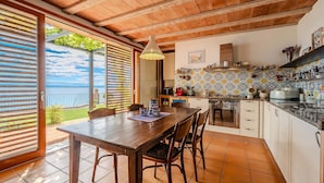 A kitchen with a view of the sea, a dining table, and a hanging light fixture. - Villa Perfect house beachfront by Villas Guide (Lovran)
