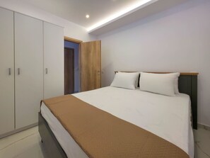 Ein Schlafzimmer mit einem Bett, einem Kleiderschrank und einer Tür zu einem anderen Raum.