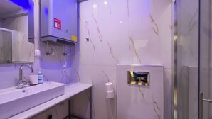 A modern bathroom with a marble vanity, a toilet, and a glass shower enclosure. - Alexandros Two-Bedroom Deluxe Suite n. 11 (Paralia)