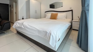 A modern bedroom with a large bed, a wardrobe, a nightstand, and a mirror on the wall. - Embassy Gardens (Accra)