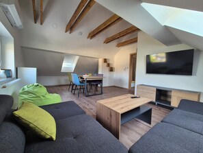 Ein modernes Loft-Apartment mit Essbereich, Fernseher und Kamin.