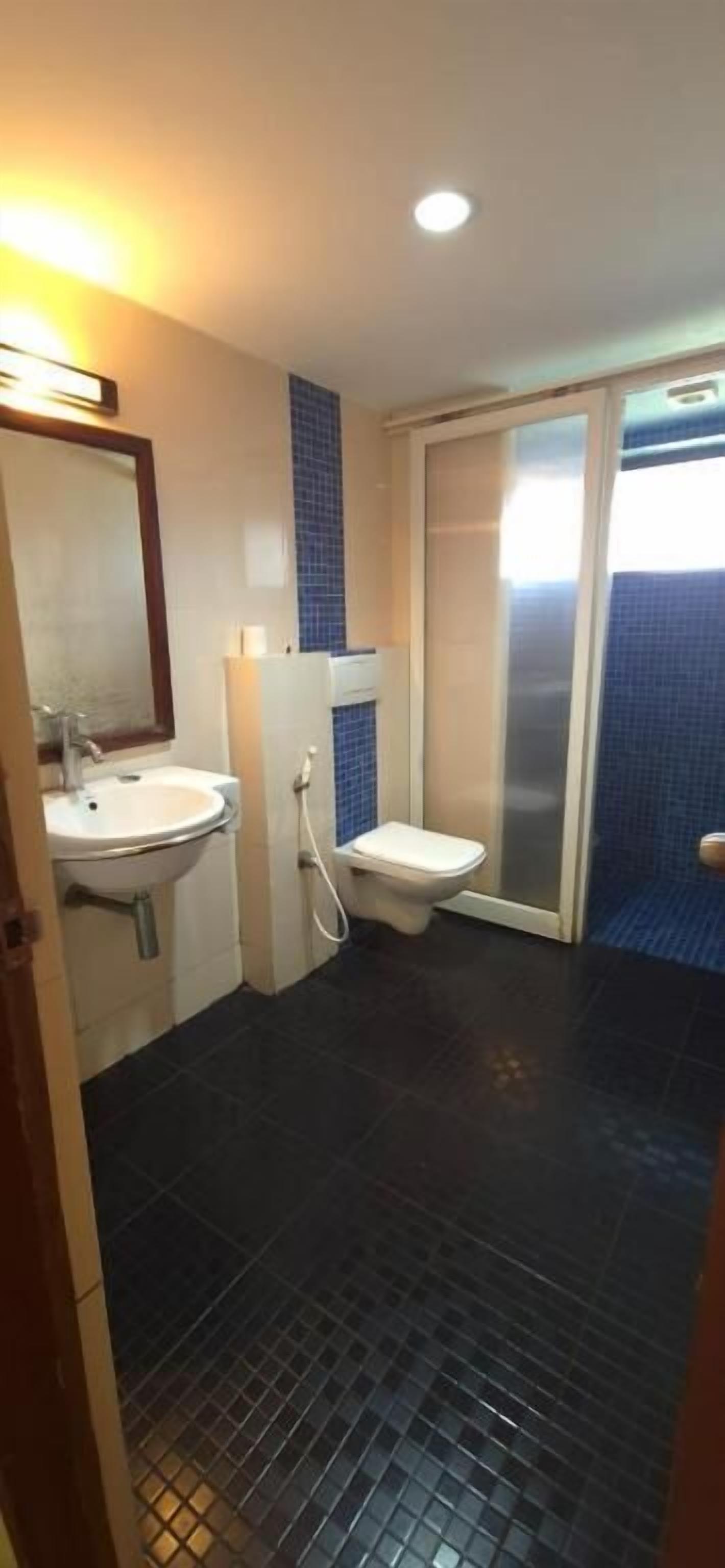 A bathroom with a sink, toilet, and shower area.