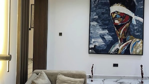 Ein modernes Wohnzimmer mit einem großen abstrakten Gemälde, einer Couch und einem Marmorboden.