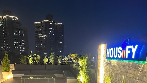 Un jardín en la azotea con un letrero que dice "HOUIFY" y una fuente.