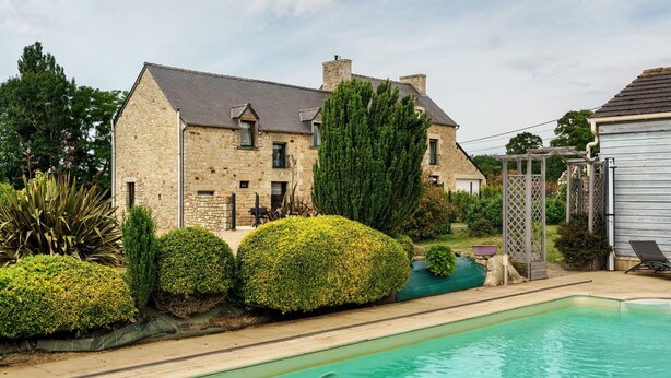 A stone house with a swimming pool, surrounded by well-maintained hedges and a garden. - Holiday Home "Gîte Les Hortensias with Pool" – Private Pool, Wi-Fi & Air Conditioning (Trébédan)