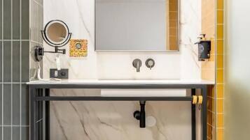 A bathroom with a marble sink, a mirror, a towel rack, and a shelf.